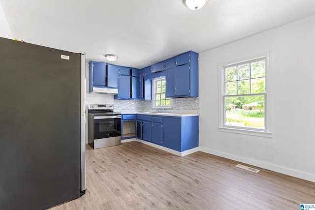 kitchen featuring under cabinet range hood, blue cabinetry, appliances with stainless steel finishes, and visible vents