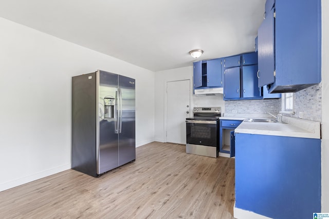 kitchen featuring blue cabinetry, a sink, light wood finished floors, under cabinet range hood, and stainless steel appliances