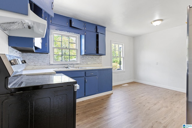 kitchen featuring light wood-style floors, blue cabinets, backsplash, and electric stove