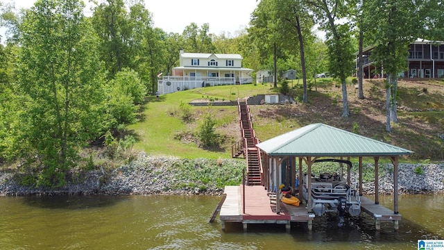 view of dock featuring fence, stairs, boat lift, and a water view
