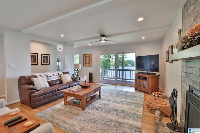 living area featuring a ceiling fan, a tile fireplace, light wood finished floors, and recessed lighting