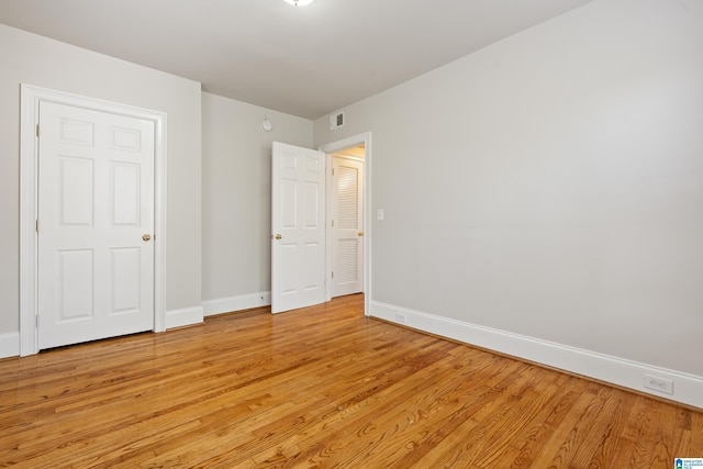 unfurnished bedroom with light wood-style floors, visible vents, and baseboards