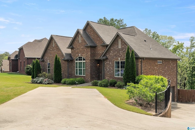 view of front of home featuring fence, a front lawn, and brick siding