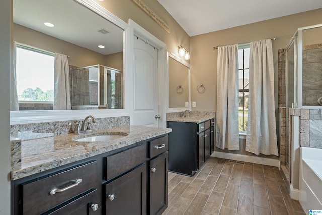 bathroom with visible vents, a sink, a shower stall, and a healthy amount of sunlight