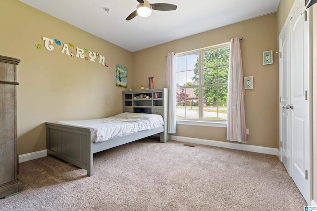 bedroom with carpet floors, visible vents, a ceiling fan, and baseboards