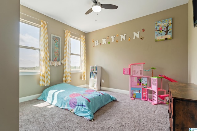 carpeted bedroom with a ceiling fan and baseboards
