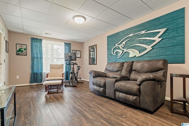 living room with baseboards, visible vents, wood finished floors, and a drop ceiling