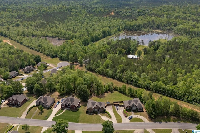drone / aerial view with a residential view, a wooded view, and a water view