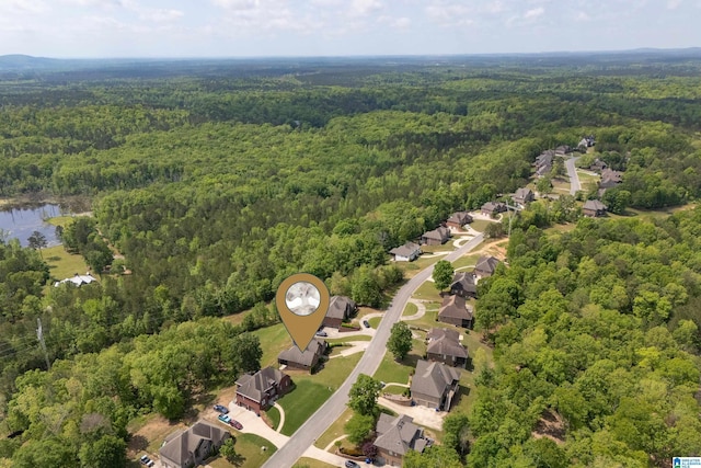drone / aerial view featuring a residential view, a view of trees, and a water view