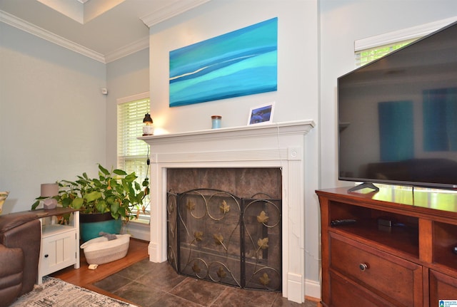 living room featuring crown molding, dark wood-style flooring, a healthy amount of sunlight, and a fireplace