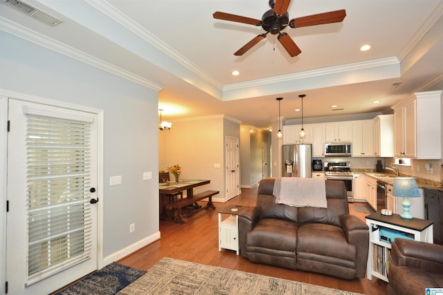 living area featuring visible vents, crown molding, dark wood-style flooring, baseboards, and ceiling fan