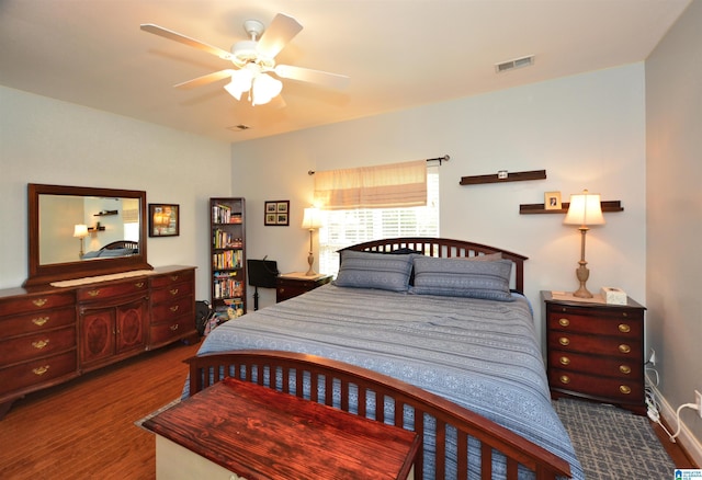 bedroom featuring a ceiling fan, visible vents, and wood finished floors