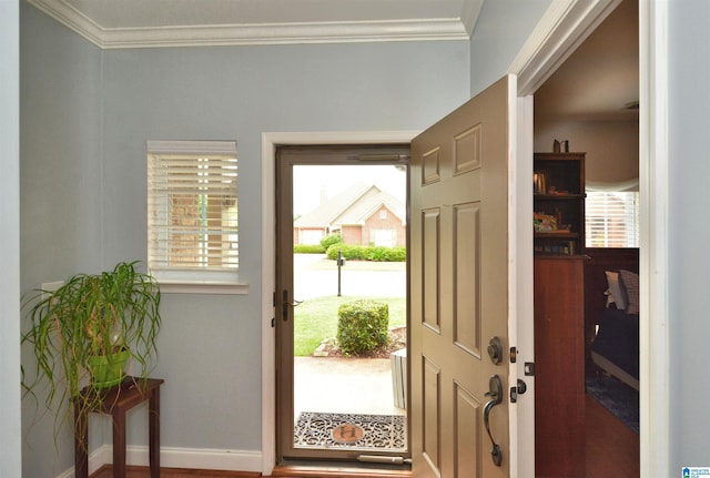 foyer entrance featuring crown molding and baseboards