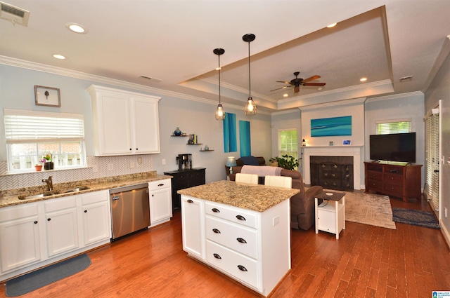 kitchen featuring a sink, a ceiling fan, stainless steel dishwasher, a tray ceiling, and visible vents