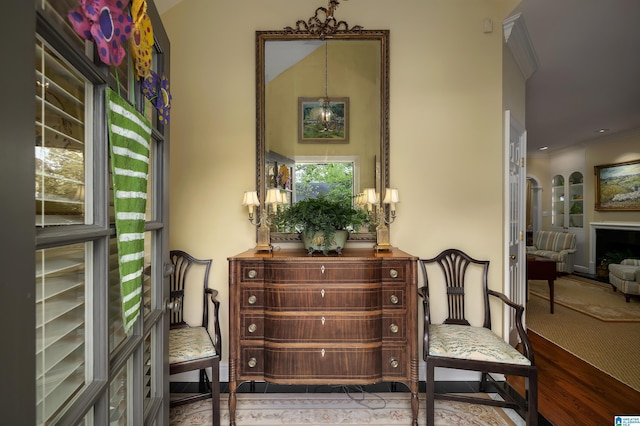 living area featuring crown molding, an inviting chandelier, and wood finished floors