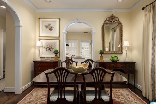 sitting room featuring dark wood finished floors, baseboards, arched walkways, and ornamental molding