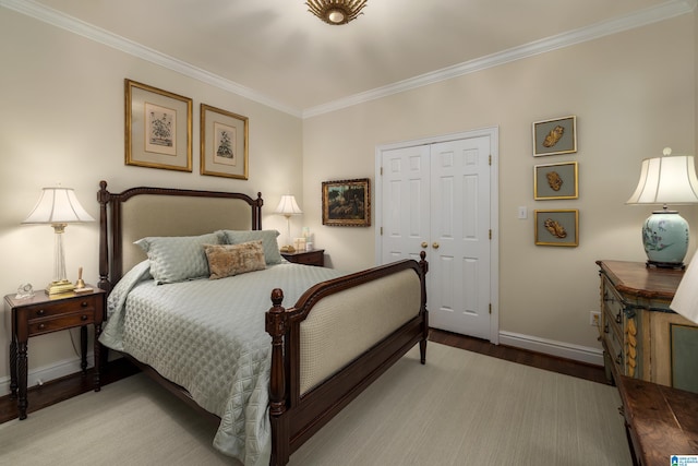 bedroom with crown molding, a closet, baseboards, and light wood-style floors