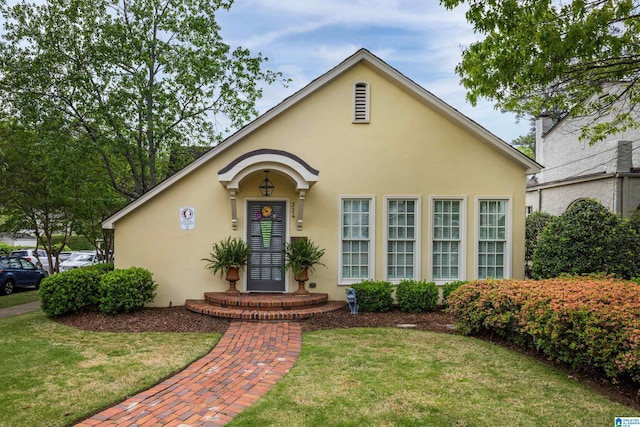 view of front of house featuring a front lawn and stucco siding