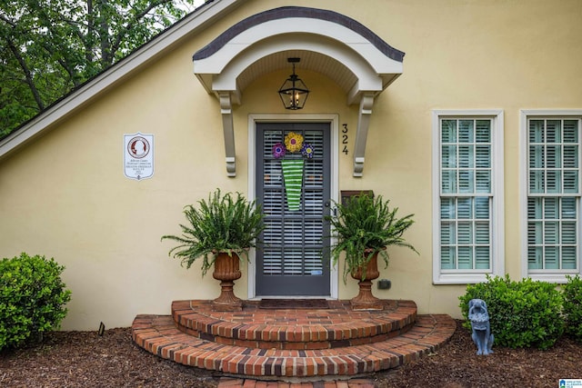 entrance to property featuring stucco siding