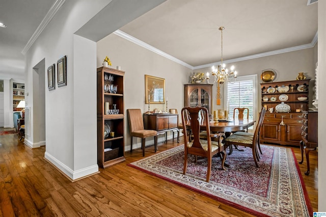 dining room with visible vents, a chandelier, baseboards, ornamental molding, and wood finished floors