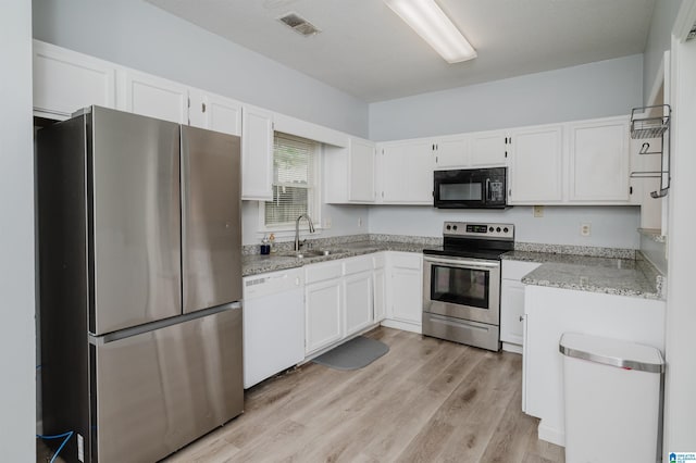 kitchen with white cabinets, stainless steel appliances, and a sink