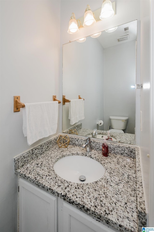 bathroom with visible vents, toilet, and vanity