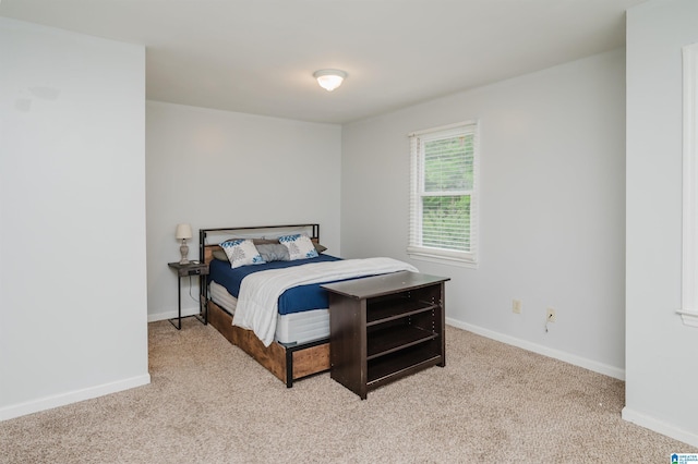 bedroom featuring baseboards and light carpet