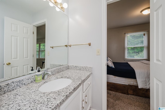 ensuite bathroom featuring a healthy amount of sunlight, vanity, and ensuite bath