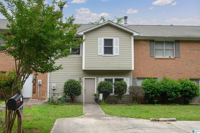 view of front facade featuring brick siding and a front yard