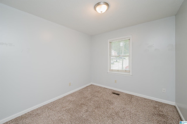 empty room with visible vents, carpet flooring, and baseboards