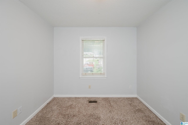 empty room featuring carpet floors, baseboards, and visible vents