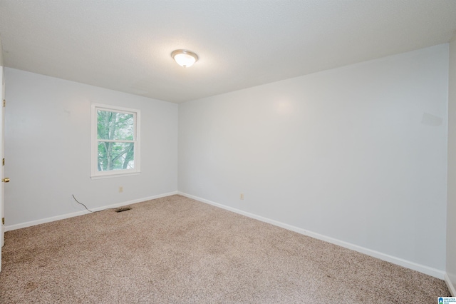 carpeted spare room with baseboards and visible vents