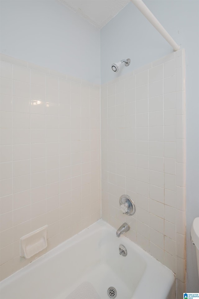 bathroom with tub / shower combination and toilet