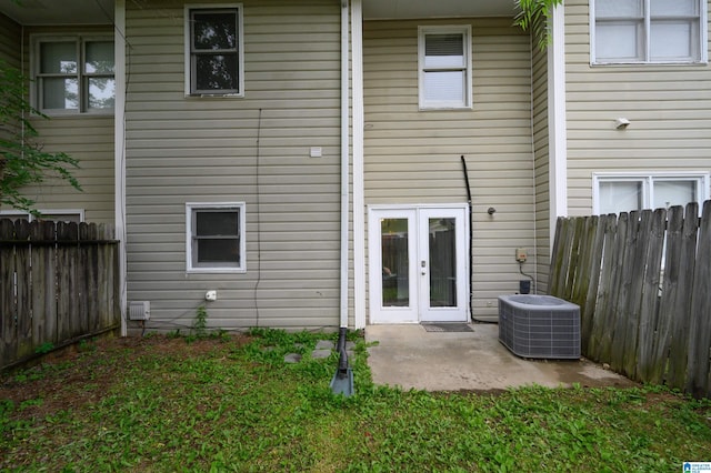 rear view of property with a patio, central AC unit, a fenced backyard, and french doors