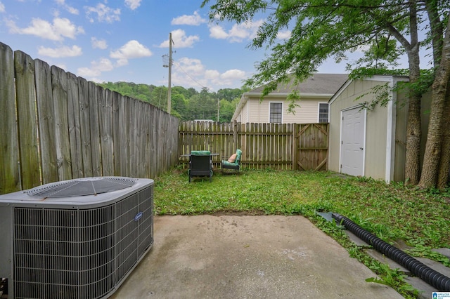 view of yard featuring a fenced backyard, an outdoor structure, central AC, and a patio area