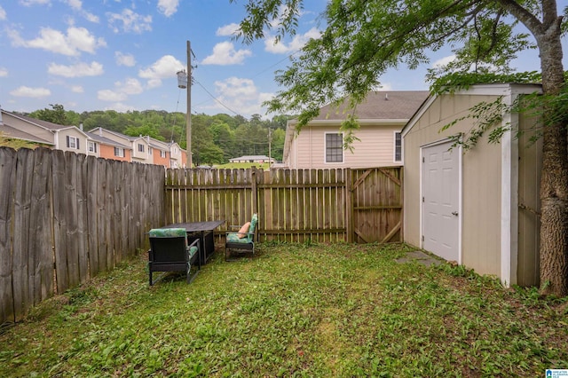 view of yard with a fenced backyard and an outbuilding