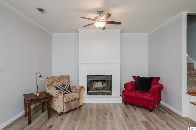 living area with stairway, ornamental molding, and wood finished floors