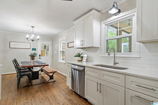 kitchen with a sink, decorative backsplash, a notable chandelier, white cabinetry, and stainless steel dishwasher