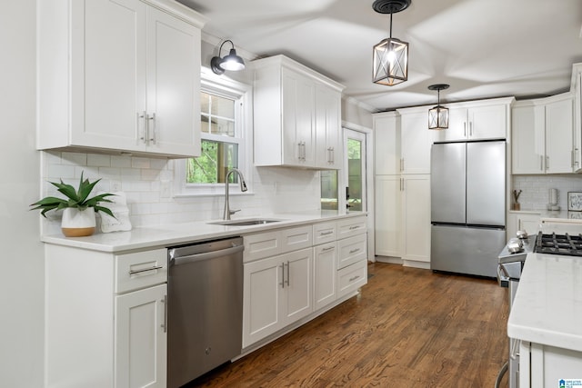 kitchen with a healthy amount of sunlight, stainless steel appliances, white cabinets, backsplash, and a sink