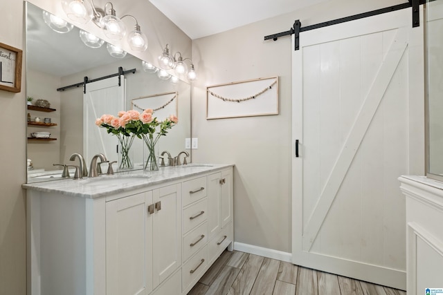 full bathroom with double vanity, a sink, and wood finished floors