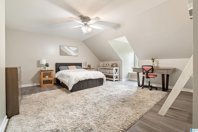 bedroom featuring wood finished floors, a ceiling fan, vaulted ceiling, and baseboards