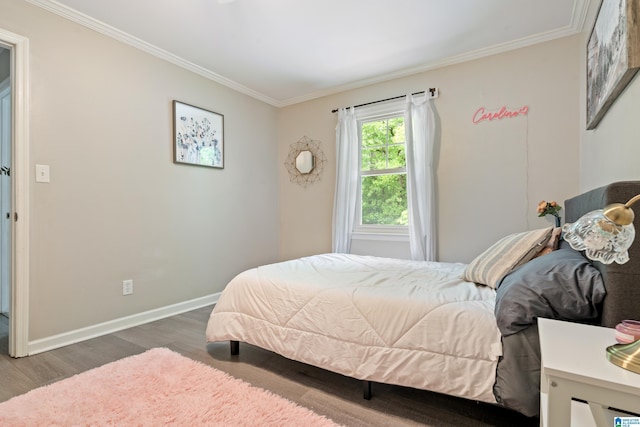 bedroom featuring wood finished floors, ornamental molding, and baseboards
