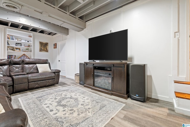 living room featuring light wood-style floors, visible vents, and baseboards
