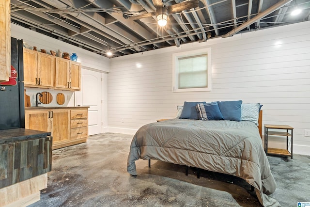 bedroom featuring wooden walls and unfinished concrete flooring