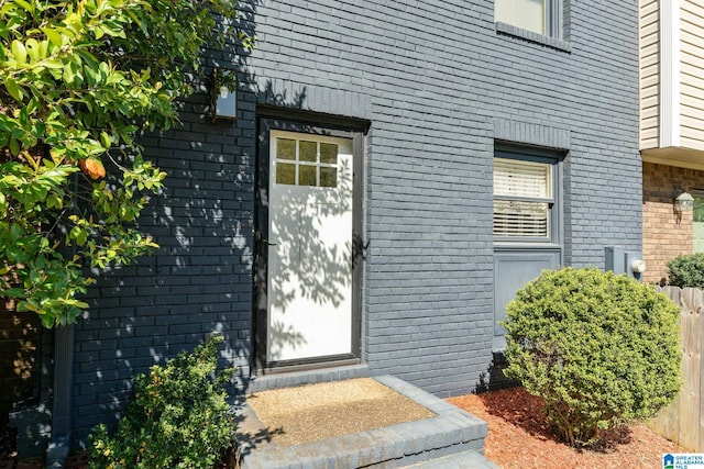 doorway to property with brick siding