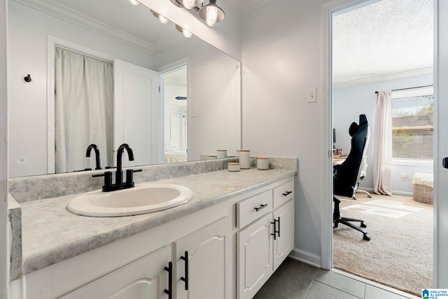 bathroom with ornamental molding, tile patterned flooring, vanity, and baseboards