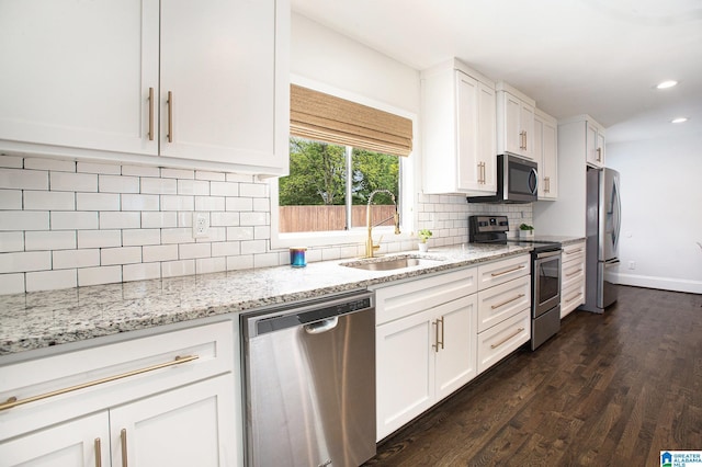 kitchen with white cabinetry, a sink, stainless steel appliances, recessed lighting, and dark wood finished floors