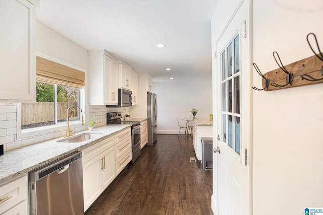 kitchen with decorative backsplash, a sink, appliances with stainless steel finishes, dark wood-style floors, and recessed lighting