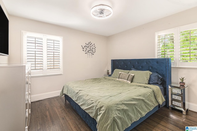 bedroom featuring dark wood finished floors and baseboards