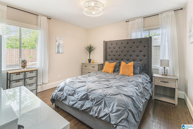 bedroom featuring multiple windows, wood finished floors, and baseboards